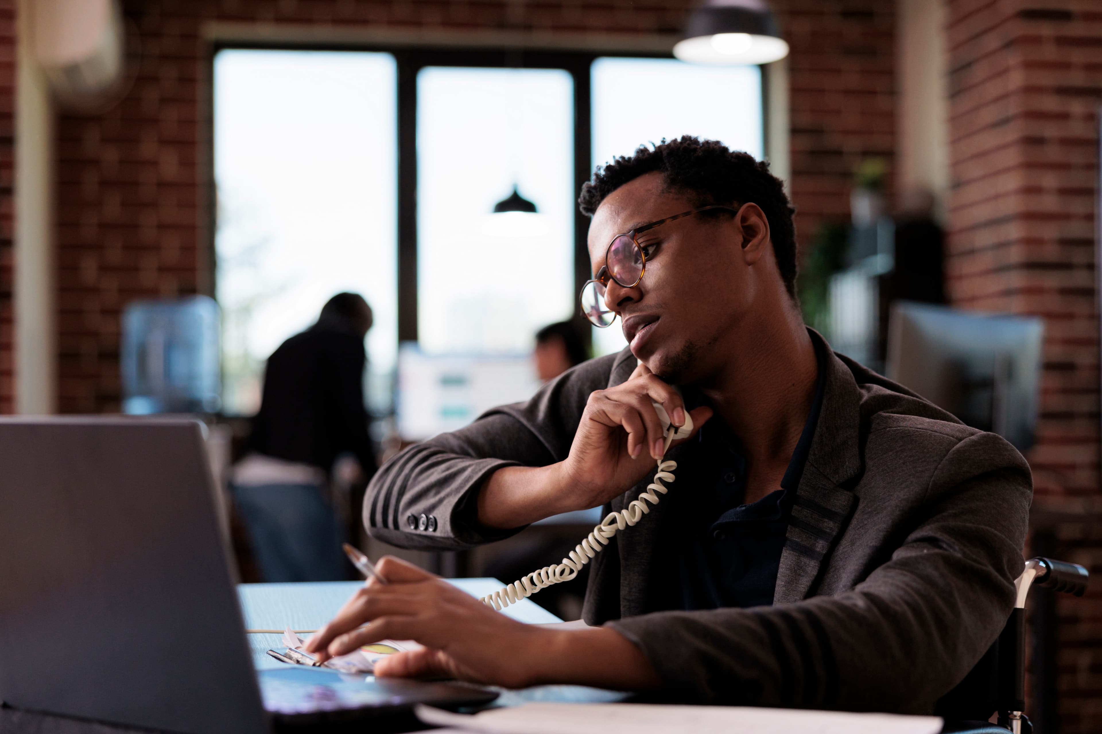 A man on a call reviewing his claim details on a laptop